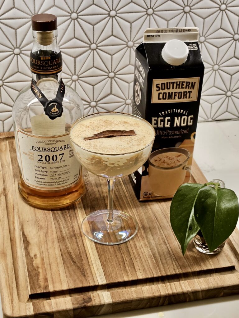 Three Ingredients for eggnog cocktail which includes eggnog, rum and cinnamon 